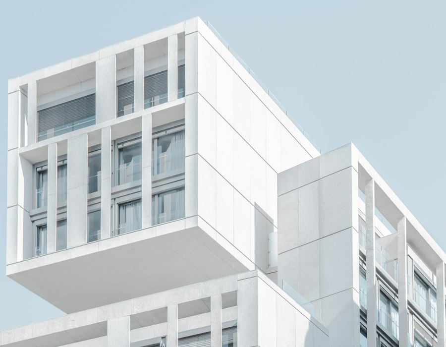 Minimal white architectural facade against a pale sky